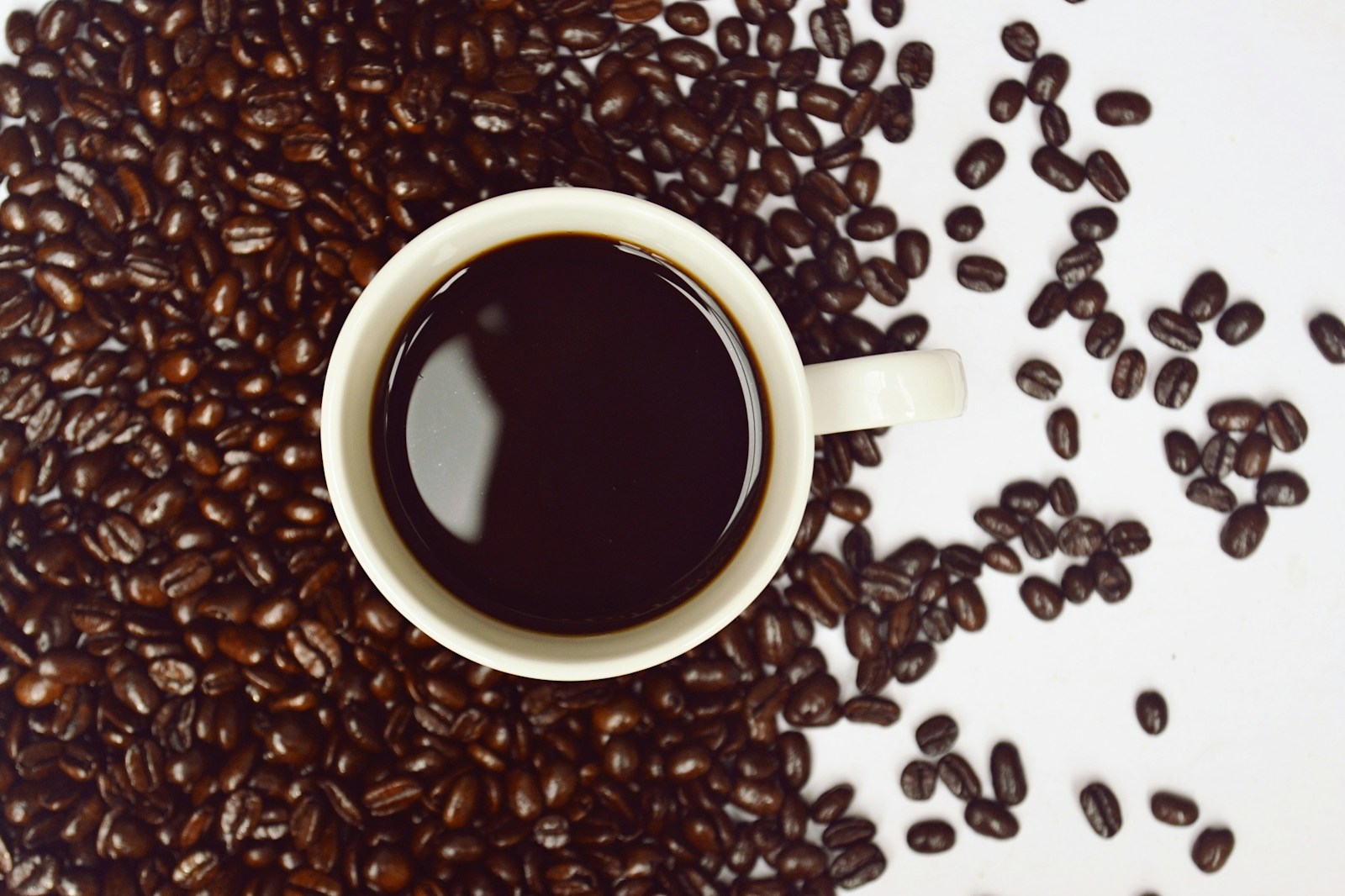 coffee cup with coffee beans close-up photography